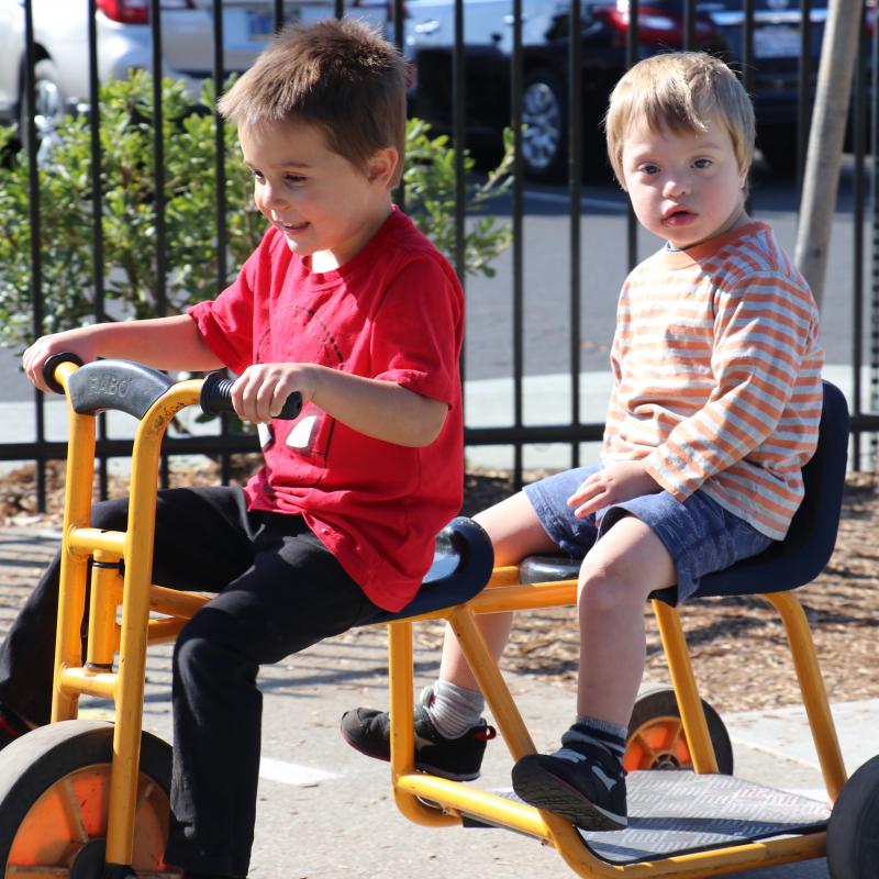 Children on a bike at the Lattice Education Achievement Preschool Two preschool children riding together on a bike